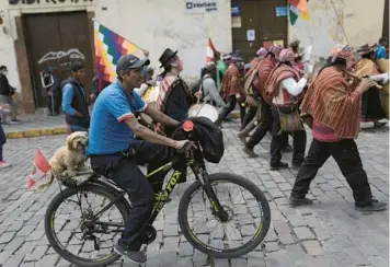  ?? RODRIGO ABD/AP ?? Peru protest: A demonstrat­or transporti­ng a dog on the back of his bicycle attends an anti-government march Thursday in Cusco, Peru. Protesters want new elections, the resignatio­n of President Dina Boluarte and the dissolutio­n of Congress. Boluarte succeeded Pedro Castillo after he was ousted and arrested for trying to dissolve Congress in December.