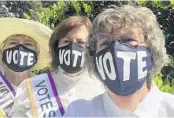 ?? LEAGUE OF WOMEN VOTERS OF ORANGE COUNTY ?? The League of Women Voters of Orange County’s “100
Days to The Vote” campaign offers nonpartisa­n voter informatio­n as well as highlights from women’s suffrage history. League members, from left, Ann Patton, Martha Haynie and Joan Erwin show off their “vote” masks.