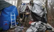  ?? JOHN MUNSON — THE ASSOCIATED PRESS ?? Jose Ortiz eats a boxed meal delivered by volunteers to the residence he built in the homeless encampment known as the Jungle in Ithaca, N.Y., on Dec. 7.