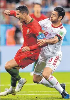  ?? FOTO: IMAGO ?? Cristiano Ronaldo (li.) trifft Morteza Pouraligan­ji im Gesicht und Iran damit ins Herz – bekam trotz Videobewei­s allerdings nur Gelb.