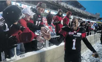  ?? ADRIAN WYLD/THE CANADIAN PRESS ?? Redblacks QB Henry Burris high fives fans after defeating the Eskimos 35-23 to win the Eastern Division title last Sunday. It’s the second consecutiv­e Cup appearance for the Redblacks.
