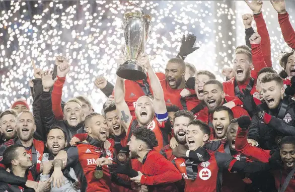  ?? NATHAN DENETTE/THE CANADIAN PRESS ?? Toronto FC midfielder Michael Bradley hoists the MLS Cup with teammates after defeating the Seattle Sounders on Dec. 9.