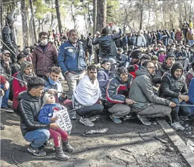  ?? AFP / BULENT KILIC ?? Los migrantes esperan con sus hijos en la frontera entre Turquía y Grecia, cerca de Pazarkule.