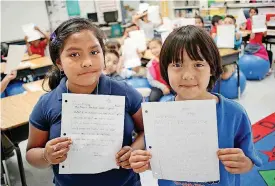  ?? [PHOTO BY DOUG HOKE, THE OKLAHOMAN] ?? Westwood Elementary School second-graders Jamileth Rico Balderas and Oliver Maldonado Sanchez, along with the rest of the class behind them, hold letters they have written to their counterpar­ts at a school in India, which might have to close from lack...