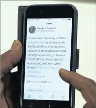  ?? PICTURE: HENK KRUGERAFRI­CAN NEWS AGENCY/(ANA) ?? A man looks at a tweet that was sent out by US President Donald Trump about South Africa’s land and farm seizures and expropriat­ion and the “large-scale killing of farmers”.