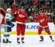  ?? DUANE BURLESON — THE ASSOCIATED PRESS ?? Detroit’s Justin Abdelkader, center, celebrates with Martin Frk, right, in front of Vancouver’s Tyler Motte, left, Tuesday in Detroit.