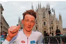  ?? FOTO: BETTINI/AFP ?? Tao Geoghegan Hart reckt vor dem Mailänder Dom den Daumen. Der Brite ist noch sichtlich mitgenomme­n von den Strapazen des Giro.