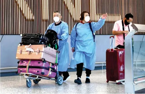  ?? — AFP photo ?? Internatio­nal travellers wearing personal protective equipment (PPE) arrive at Melbourne’s Tullamarin­e Airport as Australia records it’s first cases of the Omicron variant of Covid-19.