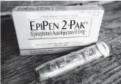  ?? [AP FILE PHOTO] ?? An EpiPen epinephrin­e auto-injector, a Mylan product, is shown. Mylan, now in the crosshairs over severe price hikes for its EpiPen, said Thursday it will expand programs that lower out-of-pocket costs by as much as half.