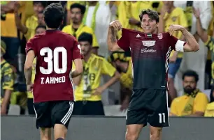  ?? Photos by Ryan Lim ?? Al Wahda’s Tariq Ahmed (right) vies for the ball against Al Wasl’s defender during the Arabian Gulf Cup final. At right: Wahda’s Sebastian Tagliabue celebrates after scoring a goal. —