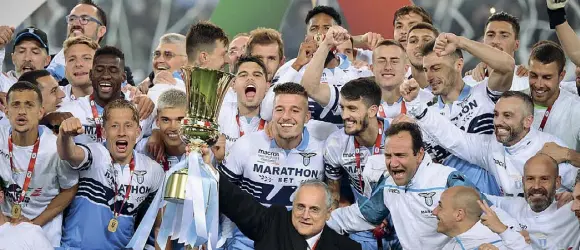  ??  ?? Presidente Claudio Lotito, 62 anni, al centro della foto con la Coppa Italia in mano, circondato dai giocatori biancocele­sti