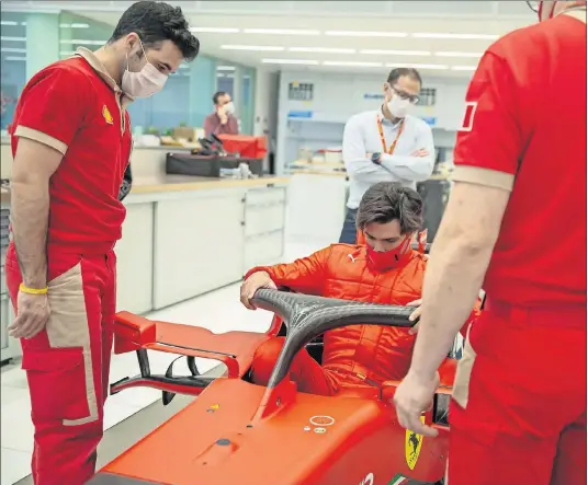  ??  ?? Carlos Sainz entra en el monoplaza de Ferrari para hacerse el asiento a medida, en su primer día de trabajo con los ingenieros de Maranello.