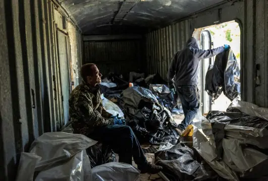  ?? John Moore, Getty Images ?? Members of a Ukrainian civil-military cooperatio­n team prepare to move the bodies of Russian soldiers on Tuesday in Kharkiv. Russian forces’ immediate goal has become the encircleme­nt of Sievierodo­netsk, the easternmos­t city in the Donbas region still under Ukrainian control.