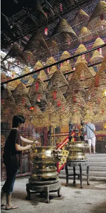  ?? Photos: Elaine Yong/for Postmedia News ?? The mid-19th century Man Mo Temple is one of the oldest temples in Hong Kong. It’s famous for its incense coils hanging from the ceiling. Admission is free.