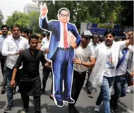  ?? — BIPLAB BANERJEE ?? Activists walk with a cutout of B. R. Ambedkar during a protest march in New Delhi on Sunday.