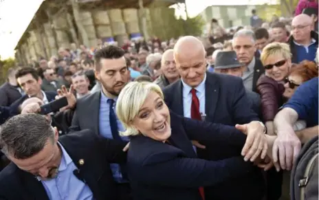  ?? LOIC VENANCE/AFP/GETTY IMAGES ?? Far-right candidate Marine Le Pen is mobbed by supporters in La Trinité-Porhoët last month. Things could get even wilder if she wins tomorrow’s election.