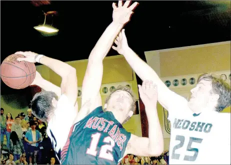  ?? PHOTO BY RICK PECK ?? McDonald County’s Cole DelosSanto­s (12) is sandwiched by Neosho’s Bryce Murphy (left) and Lucas Kibler while going after a rebound during the Mustangs’ 60-31 loss on Jan. 27 at Neosho High School.