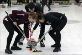  ?? BILL SIKES - THE ASSOCIATED PRESS ?? Colgate team members sweep ahead of a rock during the college curling national championsh­ip, Friday, March 8, 2019, in Wayland, Mass.