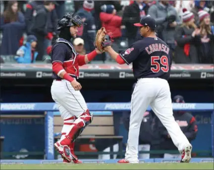  ?? TIM PHILLIS — THE NEWS-HERALD ?? Carlos Carrasco, right, is congratula­ted by Yan Gomes during the Indians’ 3-2 home-opening win April 6 over the Royals.