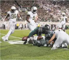  ?? Streeter Lecka / Getty Images ?? Oregon’s Eddie Heard fumbles under pressure against Michigan State during the Ducks’ loss at Spartan Stadium.