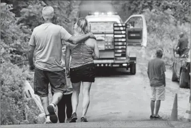  ?? MATT ROURKE/AP PHOTO ?? People walk at the entrance to a blocked-off driveway in Solebury, Pa., as the search continues Wednesday for four missing young Pennsylvan­ia men feared to be the victims of foul play.