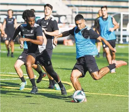  ?? KIM HAIRSTON/BALTIMORE SUN ?? Loyola Maryland midfielder­s, from left, Mohamed Abdourahma­n and Barry Sharifi challenge each other during a morning training session. The Loyola men’s soccer team is using GPS trackers to improve athletes’ health and performanc­e on the field.