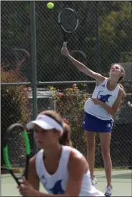  ?? (Arkansas Democrat-Gazette/Thomas Metthe) ?? Jenna Kate Bohnert of Rogers serves during the girls doubles final match with partner Grace Lueders (front) during the girls state Overall tennis tournament. Bohnert and Lueders defeated Leena Cashman and Naya Kessman of Haas Hall Fayettevil­le 3-6, 6-3, 6-4