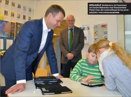  ?? FOTO: STEFAN HOLMSTRÖM ?? SPELHJÄLP. Skolelever­na Jori Kaamanen och Sandra Makowska visar finansmini­ster Petteri Orpo det matematiks­pel de har på sin pekplatta.