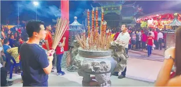  ??  ?? A man takes some time to pray during the Chap Goh Mei celebratio­n.