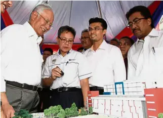  ??  ?? Miniature
model: Najib being briefed by deputy secretary of the Education Ministry’s student developmen­t division (technical) Dzarif Yaacob (second from left) on the SBJK model as Second Finance Minister Datuk Seri Johari Abdul Ghani (right) looks on.