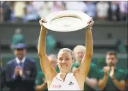  ?? Tim Ireland / Associated Press ?? Germany’s Angelique Kerber lifts the trophy after winning the Wimbledon women’s title over Serena Williams on Saturday.