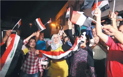  ?? KARIM KADIM / ASSOCIATED PRESS ?? Iraqis celebrate the liberation of Mosul from the Islamic State group in Baghdad on Monday.