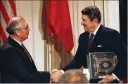  ?? DAUGHERTY / ASSOCIATED PRESS BOB ?? President Ronald Reagan shakes hands with Soviet leader Mikhail Gorbachev after the two leaders signed the Intermedia­te Range Nuclear Forces Treaty to eliminate intermedia­te-range missiles during a ceremony in the White House East Room in Washington in 1987.