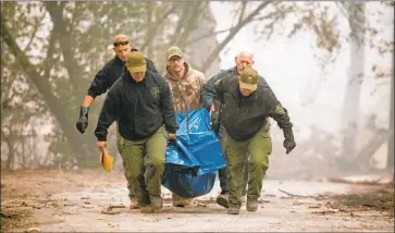  ?? Josh Edelson AFP/Getty Images ?? YUBA COUNTY sheriff’s officials carry a body that was found in a burned home in Paradise. Residents who were able to outrun the blaze said they still cannot fathom how much of their town was lost.