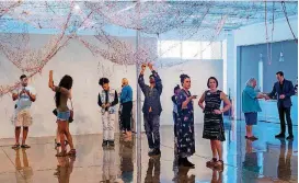  ?? [PHOTO PROVIDED] ?? Families add knots to A Thread X A Thread at the opening of “Chiyoko Myose: Sojourning.” Myose began this piece in Kansas, to demonstrat­e her wish to treasure each meeting, as a traveler in a new place. Since then, the piece has traveled to other...