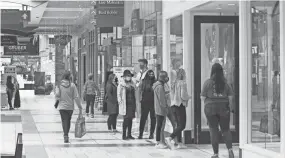  ?? MICHAEL SEARS / MILWAUKEE JOURNAL SENTINEL ?? People wait to get into the American Eagle Outfitters store at Brookfield Square on Sunday. There is a limit on the number of people due to pandemic precaution­s.