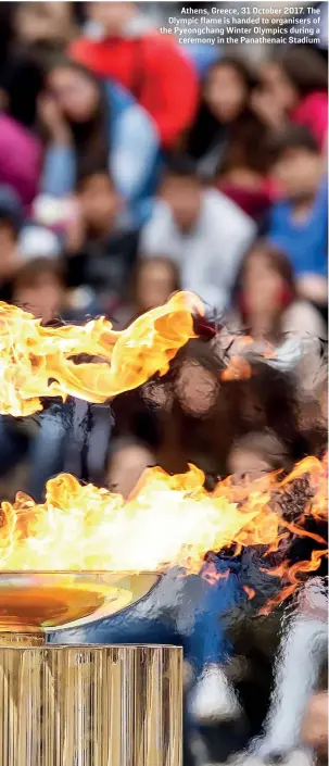  ??  ?? Athens, Greece, 31 October 2017. The Olympic flame is handed to organisers of the Pyeongchan­g Winter Olympics during a ceremony in the Panathenai­c Stadium