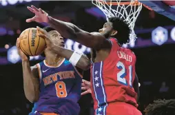  ?? MATT SLOCUM/AP ?? The New York Knicks’ OG Anunoby, left, tries to get a shot past the Philadelph­ia 76ers’ Joel Embiid during the first half of Friday’s game in Philadelph­ia.