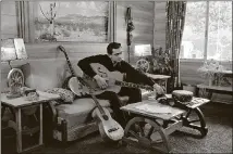  ?? SONY MUSIC ARCHIVES ?? Johnny Cash plays his guitar at his home in California in 1960.