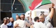  ??  ?? POLITICAL prisoners Mohammed al-Bushi and Hisham Ali hug relatives and supporters after their release from jail in Khartoum yesterday – the first two to be freed in a pledge by the military council that took over from former president Omar al-Bashir. |