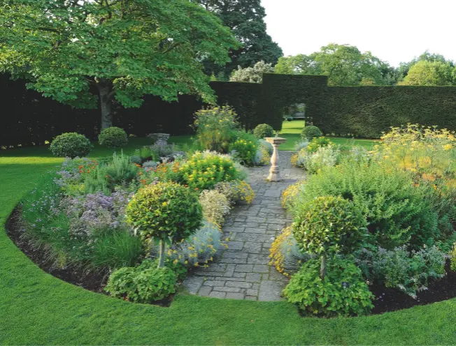  ??  ?? The Herb Garden within the Yew Circle. Wild strawberri­es grow under the standard bay trees, joined by a range of culinary herbs, including fennel, oregano, marigold, borage, mint and thyme