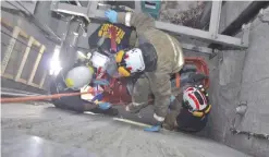  ??  ?? Rescue workers remove the body of a man who fell in the elevator shaft of a building under constructi­on.