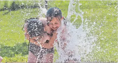  ?? BOB TYMCZYSZYN THE ST. CATHARINES STANDARD ?? Sisters Kali and Jaia Robins cool off at the Catherine Street Park splash pad in
St. Catharines. Temperatur­es hit 32 C Monday.