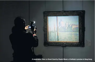  ??  ?? A cameraman films Le Grand Canal by Claude Monet, at Sotheby’s preview in Hong Kong.