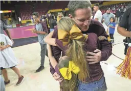  ??  ?? Roman Rozell, 35, hugs his daughters following an ASU wrestling meet at Desert Financial Arena in Tempe on Nov. 15.
