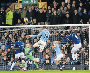  ?? Picture: GETTY IMAGES/ACTION PLUS/DAVID BLUNSDEN ?? HIGH AND MIGHTY: Manchester City’s Aymeric Laporte heads past Everton keeper Jordan Pickford to score the opening goal of the match. Manager Pep Guardiola feels the win proves City’s title race is still on.