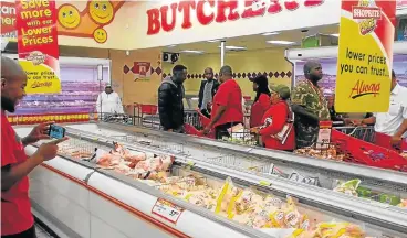  ?? /Supplied ?? “Helping hand”: EFF members invade a supermarke­t, claiming to be helping them throw away all Rainbow and Enterprise products following the findings on listeriosi­s.