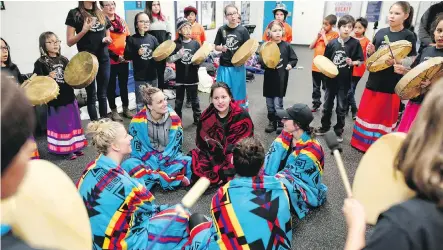  ?? PHOTOS: LEAH HENNEL ?? Students from Piitoayis Family School honour Brigette Lacquette, centre, the first Indigenous player on the women’s Olympic hockey team, and other members of Team Canada with a drum ceremony during a meeting Wednesday at WinSport in Calgary.