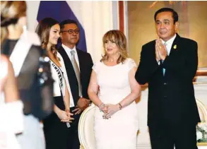  ??  ?? Thailand’s Prime Minister Prayut Chan-o-cha, right, greets the president of Miss Universe Organisati­on Paula Shugart (second-right) and Miss Universe 2018 contestant­s during a meeting at the Government House in Bangkok yesterday.