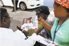  ??  ?? Porsha Dixson (right) holds flyers for Ellis’ memorial. Dixson was working at St. Boniface and called 911 when he collapsed.